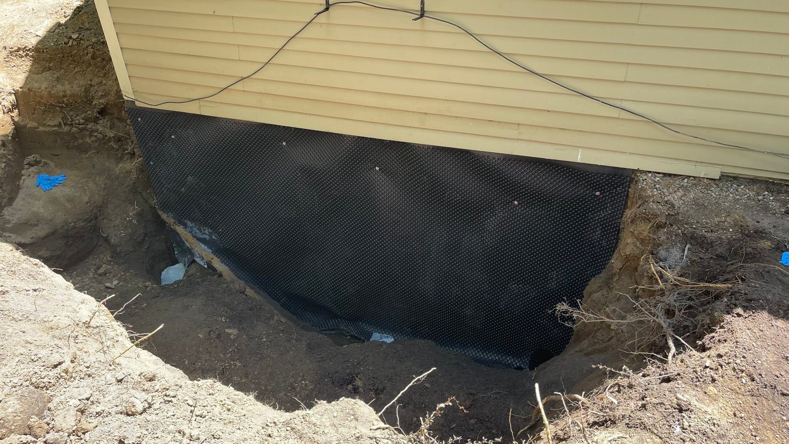Top Course Masonry experts preparing the basement for a complete waterproofing service